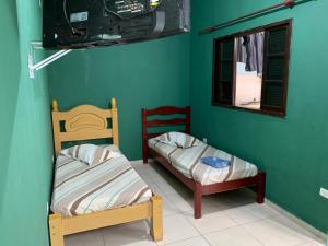 duas camas num quarto com paredes verdes em Hotel Vila de São Vicente em São Vicente