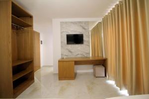 a room with a desk and a television on a wall at Hotel Four Islands in Ksamil