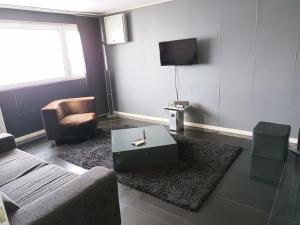 sala de estar con sofá, mesa y TV en Black Apartament nr1, en Bucarest
