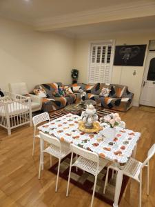ein Wohnzimmer mit einem Tisch und einem Sofa in der Unterkunft LONDON HEATHROW GLAMOUR MANSION HOUSE in Uxbridge