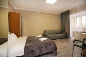 a hotel room with a bed and a couch at На бульваре Мендикулова in Almaty