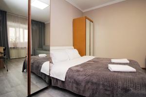 a bedroom with a bed and a mirror at На бульваре Мендикулова in Almaty