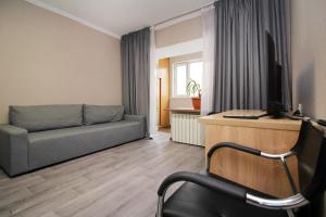 a living room with a couch and a television at На бульваре Мендикулова in Almaty