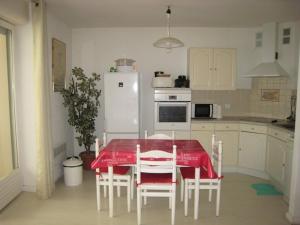 kuchnia ze stołem i krzesłami oraz białą lodówką w obiekcie Studio tout équipé avec loggia, parking et Wi-Fi à 50m des cures - 2 pers - Animaux OK - FR-1-703-22 w mieście Amélie-les-Bains-Palalda