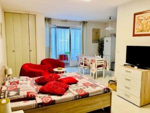 sypialnia z łóżkiem z czerwonymi krzesłami i telewizorem w obiekcie Studio tout équipé avec loggia, parking et Wi-Fi à 50m des cures - 2 pers - Animaux OK - FR-1-703-22 w mieście Amélie-les-Bains-Palalda