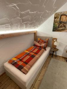 a bed with a blanket on top of it in a room at Hotel-Hauensteiner-Hof in Hauenstein