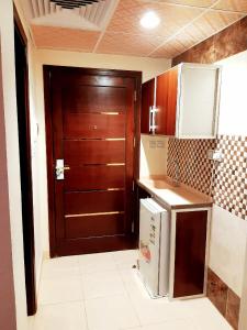 麥加的住宿－فندق انوار المشاعرالفندقية，厨房设有棕色的门和冰箱。