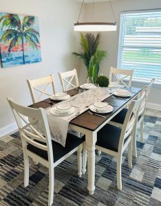 布雷登顿NEW Renovated luxury home with private heated pool, game room Near Anna Maria Island and IMG的有桌子和椅子的餐厅