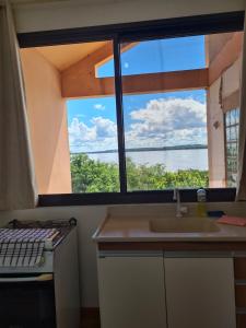 cocina con fregadero y ventana grande en Bela Vista Aparts, en Uruguaiana