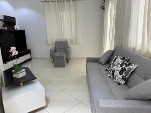 a living room with a gray couch and a chair at Casa Familiar - Guaibim in Guaibim