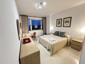 Habitación de hotel con cama, escritorio y habitación en Estupendo apartamento junto a Plaza de España, en Sevilla