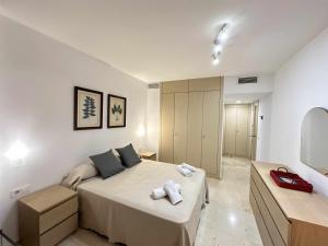 a bedroom with a bed with two towels on it at Estupendo apartamento junto a Plaza de España in Seville