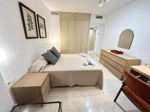 a bedroom with a bed and a dresser and a mirror at Estupendo apartamento junto a Plaza de España in Seville