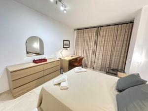 a bedroom with a bed and a desk and a mirror at Estupendo apartamento junto a Plaza de España in Seville
