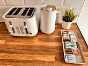 a kitchen counter with a toaster and a cell phone at Cosy & Convenient space near M1, EM Airport & City in Nottingham