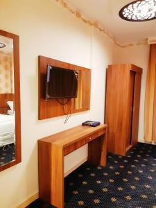 麥加的住宿－فندق انوار المشاعرالفندقية，客房设有书桌和墙上的电视