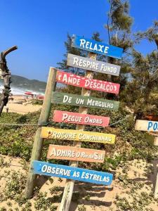 un panneau avec de nombreux panneaux différents sur la plage dans l'établissement Casa em Tucuns, à Búzios