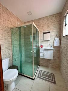 a bathroom with a glass shower and a toilet at Casa em Tucuns in Búzios