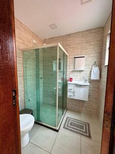 a bathroom with a glass shower and a toilet at Casa em Tucuns in Búzios