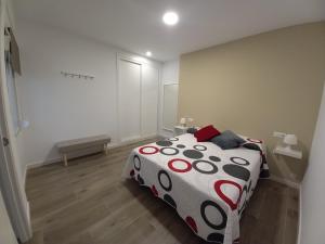 1 dormitorio con 1 cama con edredón blanco y negro en Apartamento Ramírez, en Conil de la Frontera
