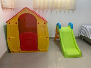 uma sala de jogos com uma casa de brinquedos e um escorrega em CASA GRAU - ZORRITOS em Caleta Grau