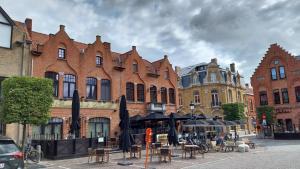 une rue avec des tables et des parasols devant les bâtiments dans l'établissement Dream@coast, à Nieuport