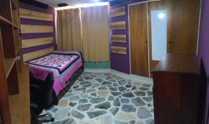 a bedroom with a bed with a rock floor at Confortable Apartamento in Mérida