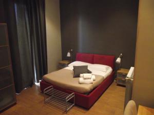 Schlafzimmer mit einem Bett mit rotem Kopfteil in der Unterkunft XX Miglia rooms & apartments in Catania