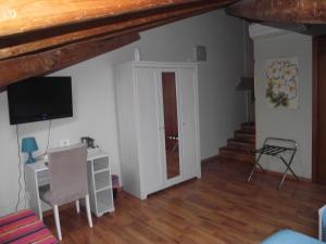 Habitación con escritorio, TV y puerta. en XX Miglia rooms & apartments, en Catania