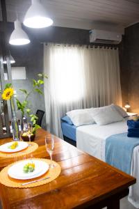 una habitación con una mesa y una cama y una habitación con 2 camas en Studio Girassol en Florianópolis