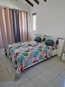 a bedroom with a bed with a colorful comforter at Villa marigua 2 in Les Abymes