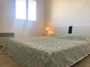 ein Schlafzimmer mit einem Bett mit einer Decke darauf in der Unterkunft Appart. moderne au calme - Bormes-les-Mimosas - WIFI, AIRCONDITIONING, PARKING - FR-1-251-461 in Bormes-les-Mimosas