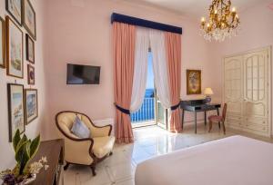 um quarto com uma cama, uma secretária e uma janela em Villa Don Guglielmo AMALFI COAST em Ravello