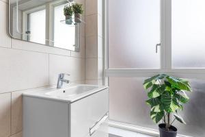 a bathroom with a sink and a mirror and a plant at Luxury Central London Apartments Bermondsey in London