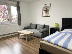 ein Schlafzimmer mit einem Bett, einem Sofa und einem Tisch in der Unterkunft Easy to Düsseldorf Messe, 2-bedroom Apartment with kitchen and garden in Duisburg
