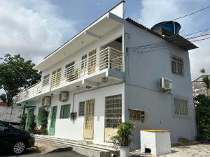 a white house with a car parked in front of it at Betesda in São Luís