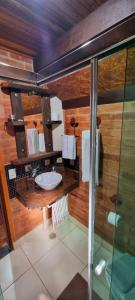 a bathroom with a sink and a shower at Ecos da Terra Chalés in Monte Verde
