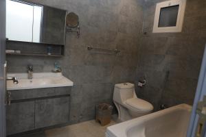 a bathroom with a sink and a toilet and a tub at Orchida Turaif Hotel 1 in Ţurayf