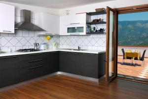a kitchen with white and black cabinets and a table at Bed And Breakfast Sunflower in Vico Equense