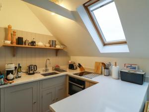 cocina con fregadero y ventana en Mistletoe Cottage, en Bamburgh