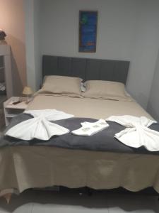 a bed with two white towels on top of it at Pousada Canoa dos Anjos suítes in Arraial do Cabo