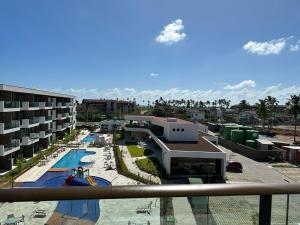 a view of a resort with a pool and a building at Muro Alto Makia flat cinematográfico in Porto De Galinhas