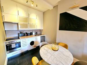 cocina con mesa, mesa y sillas en Gorgeous Hyde Park Home with Elevator Access by Tube Metro Stations, en Londres