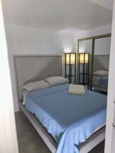 a bedroom with a blue bed with a mirror at 13101 Main Home Miami in Miami