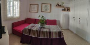 a living room with a red couch and a table at Apartamento Lerele in El Bosque