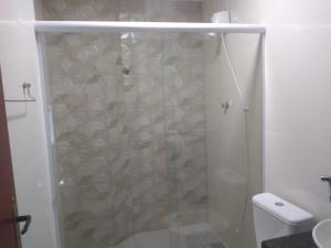 a shower with a glass door in a bathroom at Pousada Canoa dos Anjos suítes in Arraial do Cabo