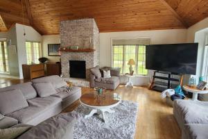 a living room with a couch and a fireplace at Prince Edward County~Water View~FREE Pontoon Boat~Sandbanks Pass in West Lake