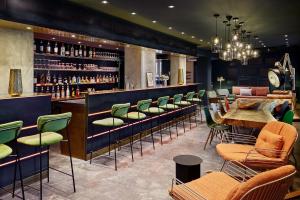 een restaurant met een bar met groene stoelen bij the Deutz, a Tribute Portfolio Hotel in Keulen