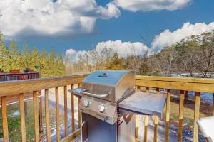 a grill sitting on a wooden railing on a porch at Bare Assets in Pigeon Forge