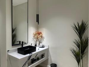 La salle de bains est pourvue d'un lavabo et d'un miroir. dans l'établissement الشقة الفاخرة vip العيينة, à Al ‘Uyaynah